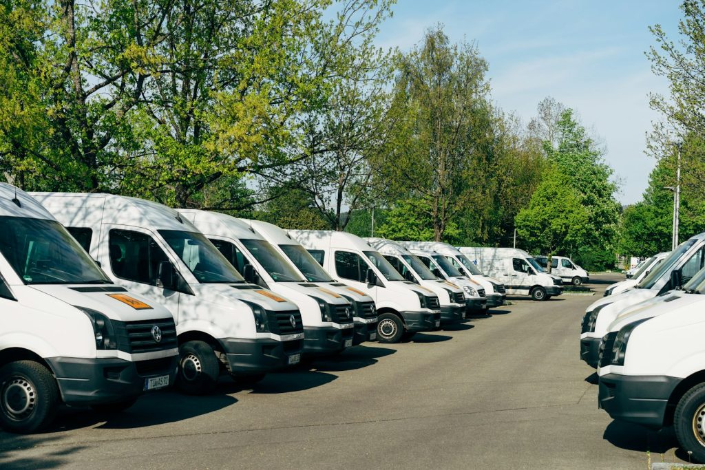 A row of white fleet vans parked together